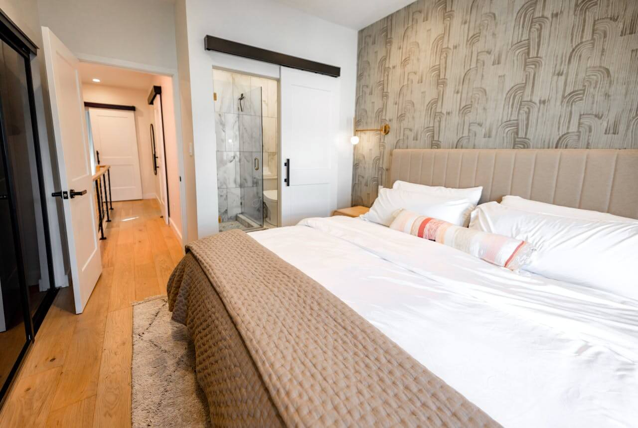 Small rectangular bedroom with queen bed centred on the long wall, open floor space on both